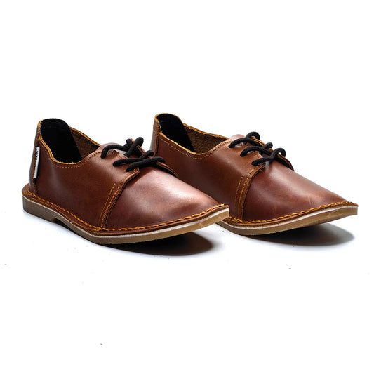 Pair of brown leather shoes with black laces on a white background