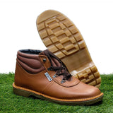 Red tan leather boot with a checkered sole on a grassy background