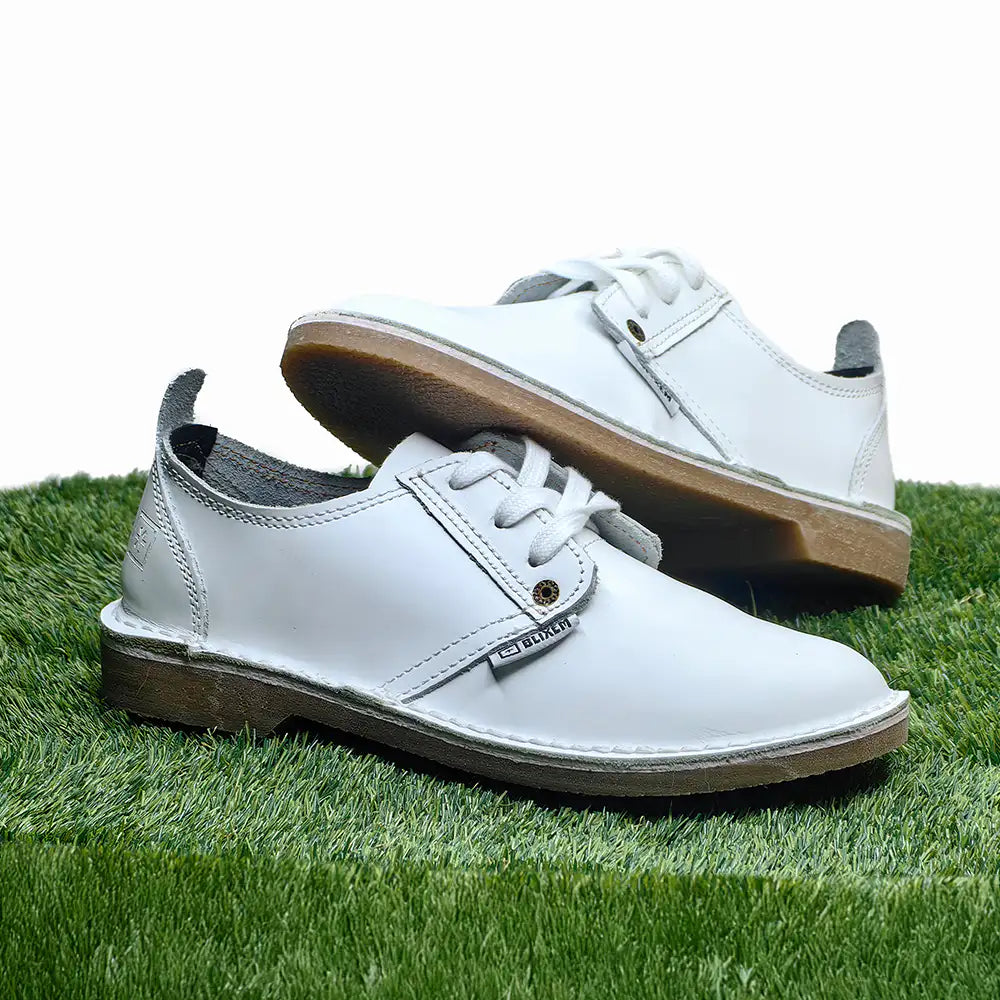 White shoes with brown soles on a grassy surface