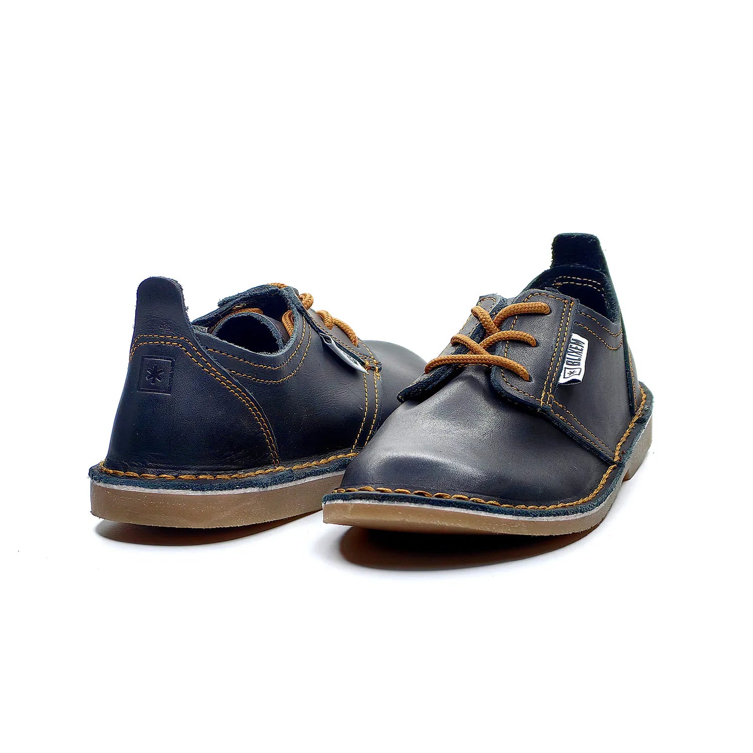 Pair of black shoes with copper gold laces on a white background