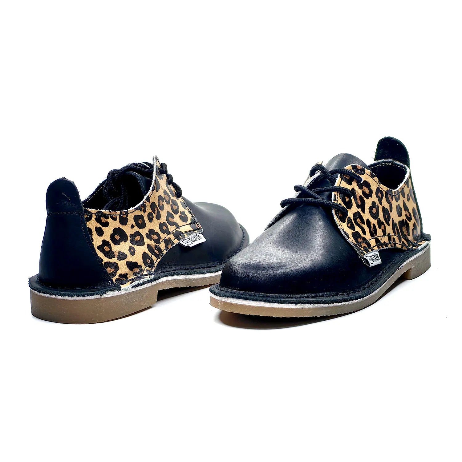 Black shoes with leopard print accents on a white background