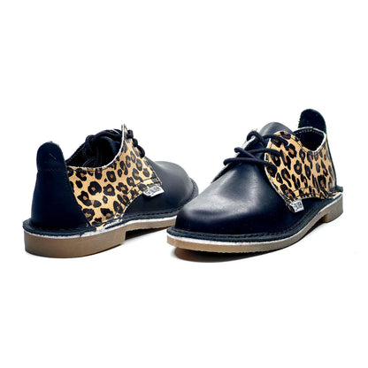Black shoes with leopard print accents on a white background