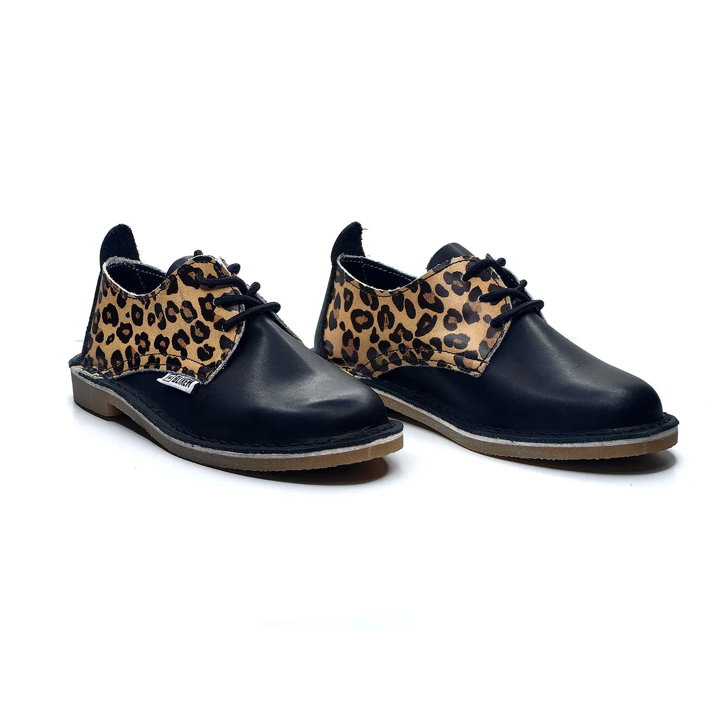 Pair of black shoes with leopard print accents on a white background