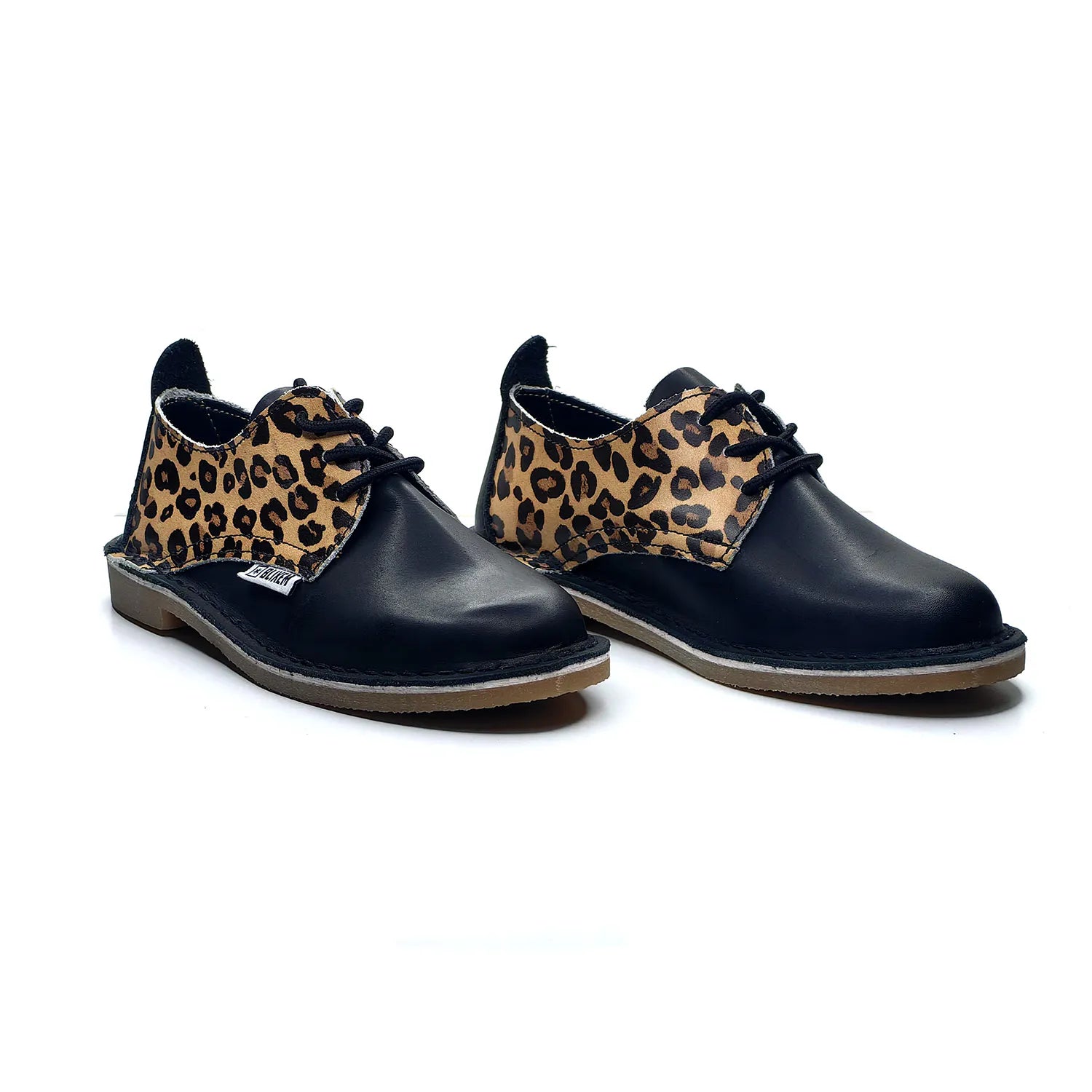 Pair of black shoes with leopard print accents on a white background