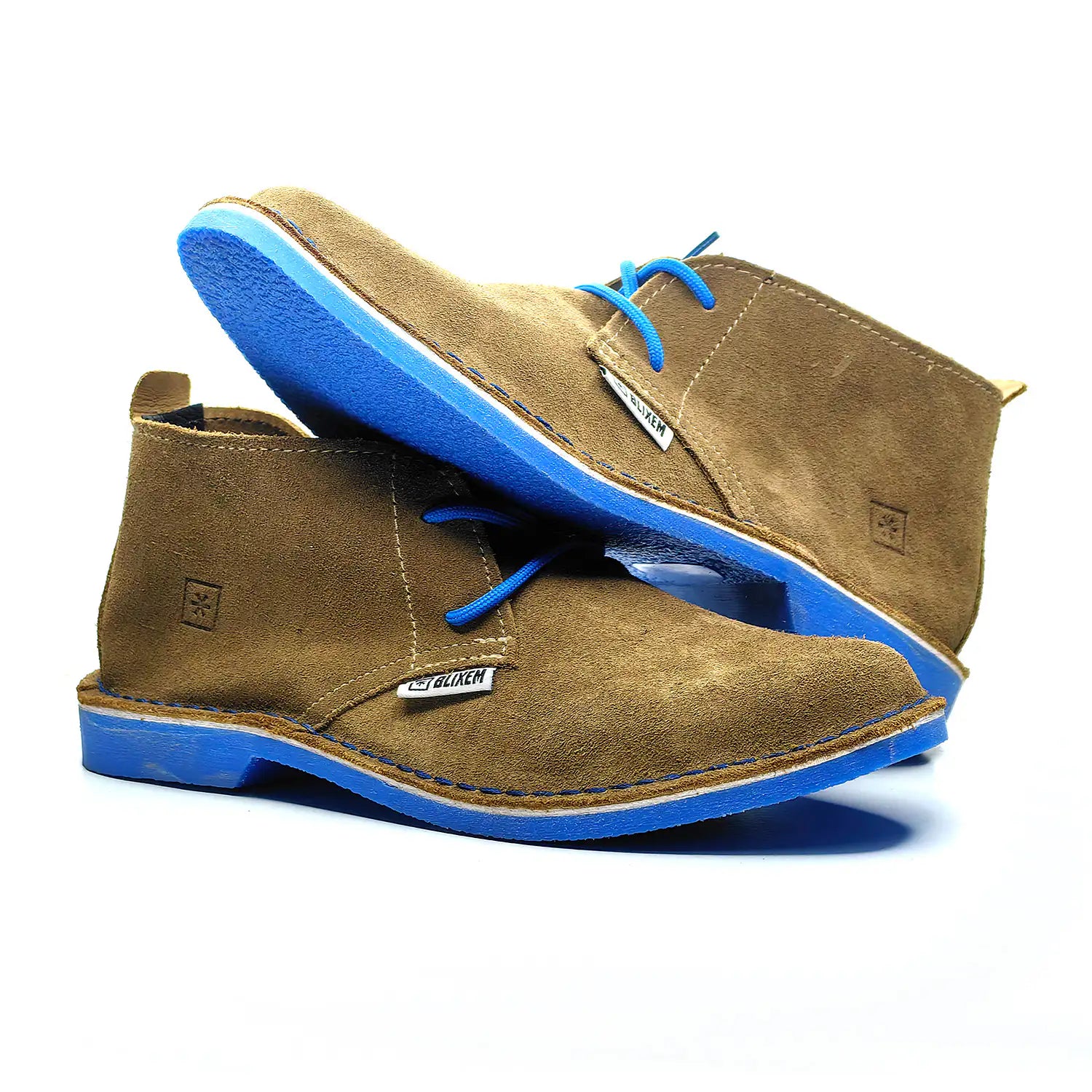 Brown suede shoes with blue soles on a white background