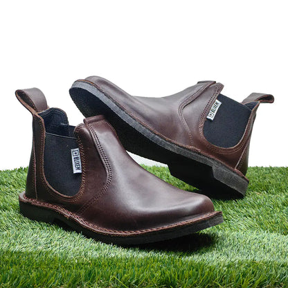 Brown leather boots on a grassy surface