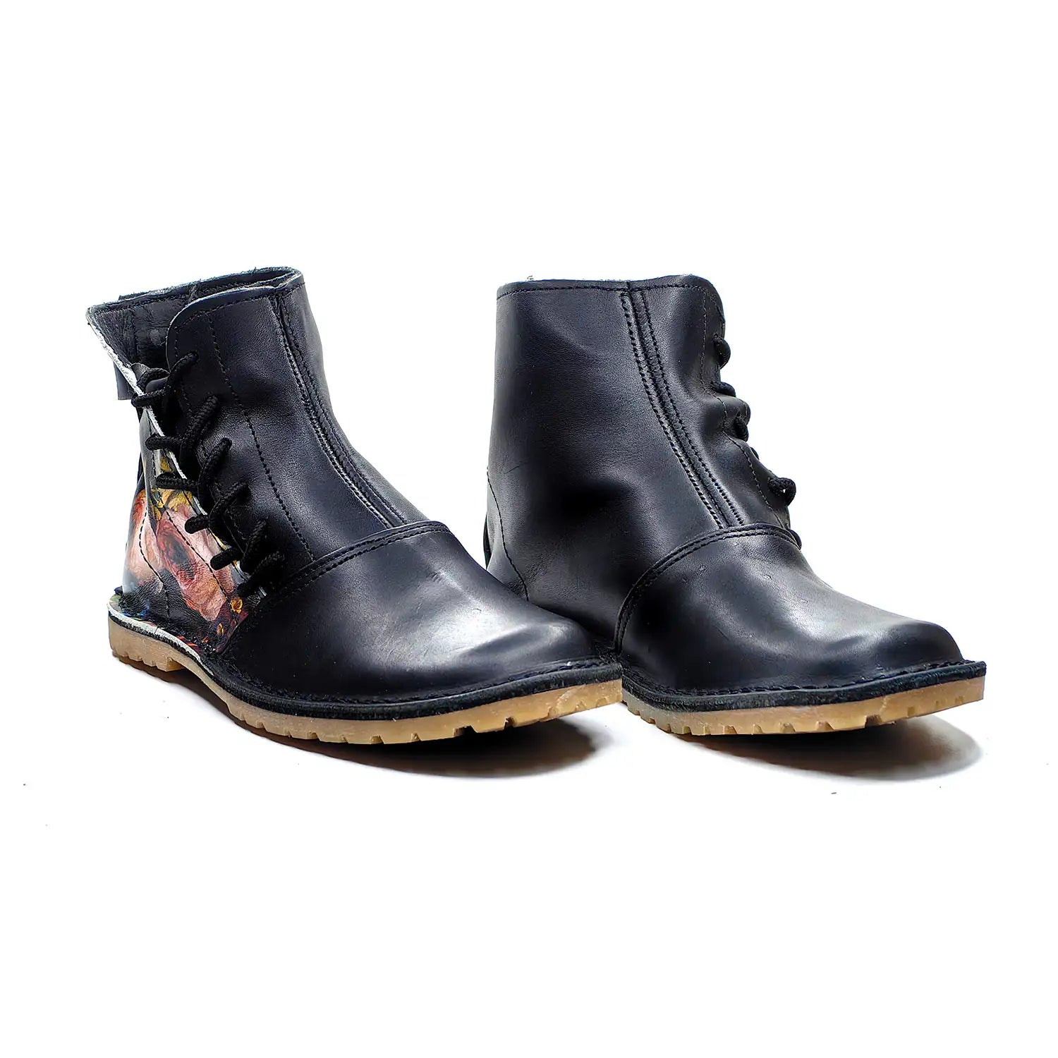Pair of black leather boots with floral design on a white background