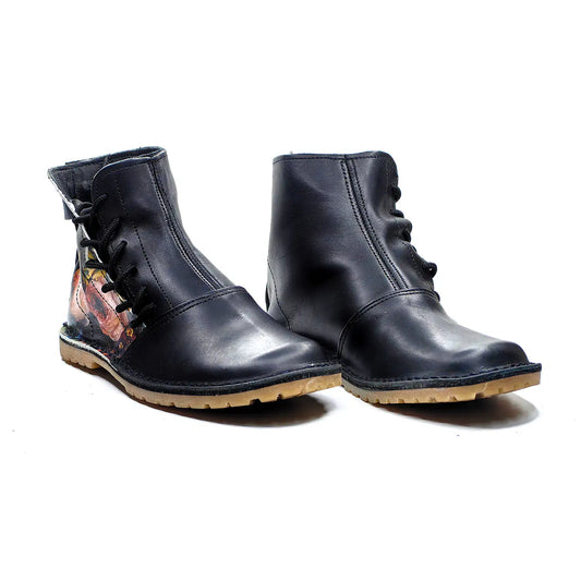 Pair of black leather boots with floral design on a white background