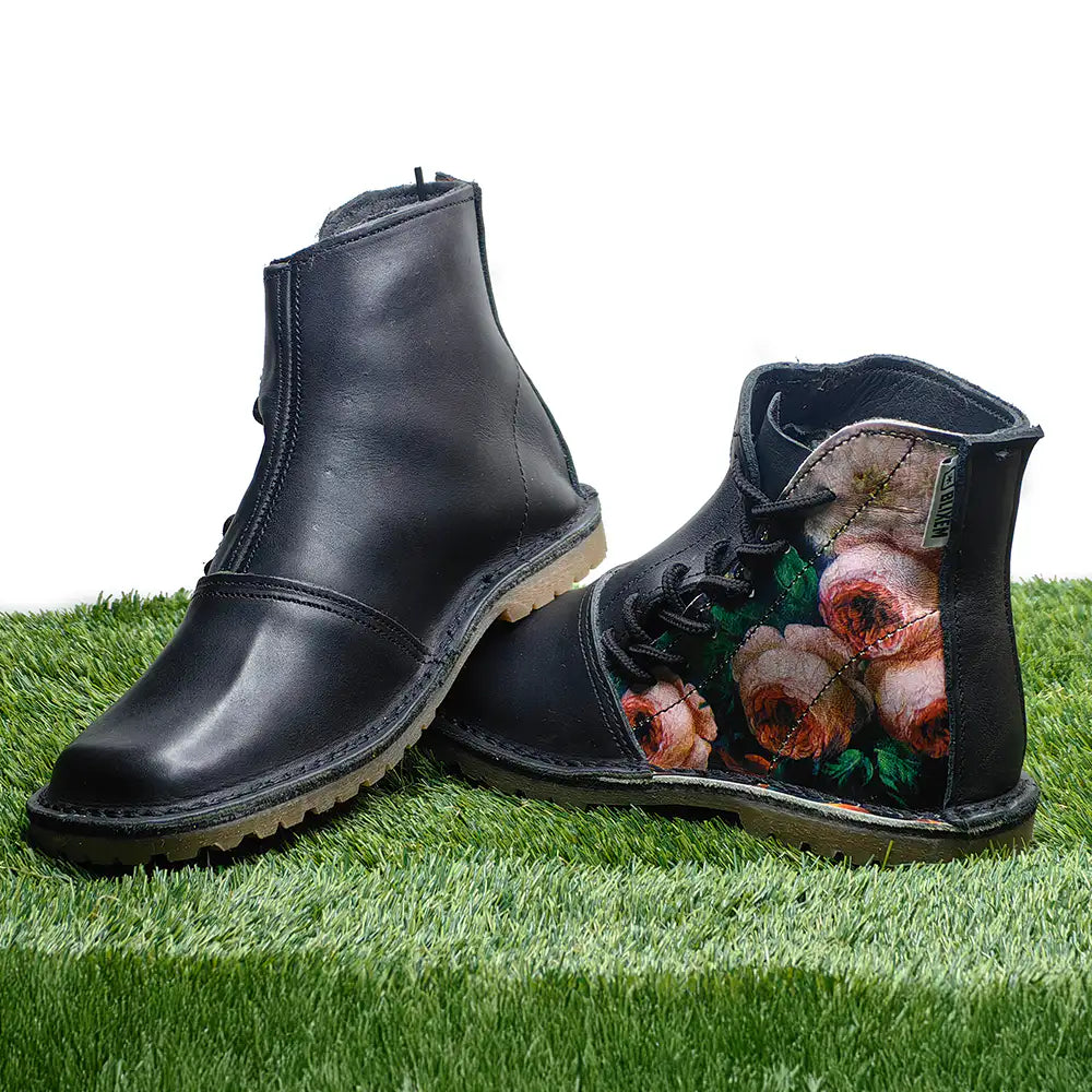 Black boots with floral pattern on grass