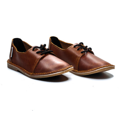 Pair of brown leather shoes with black laces on a white background