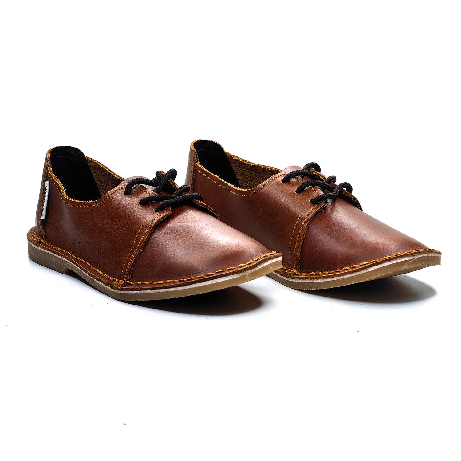 Pair of brown leather shoes with black laces on a white background