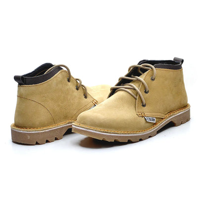 Pair of tan nubuck leather boots with black soles on a white background