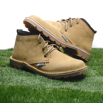Pair of tan boots on a grassy surface