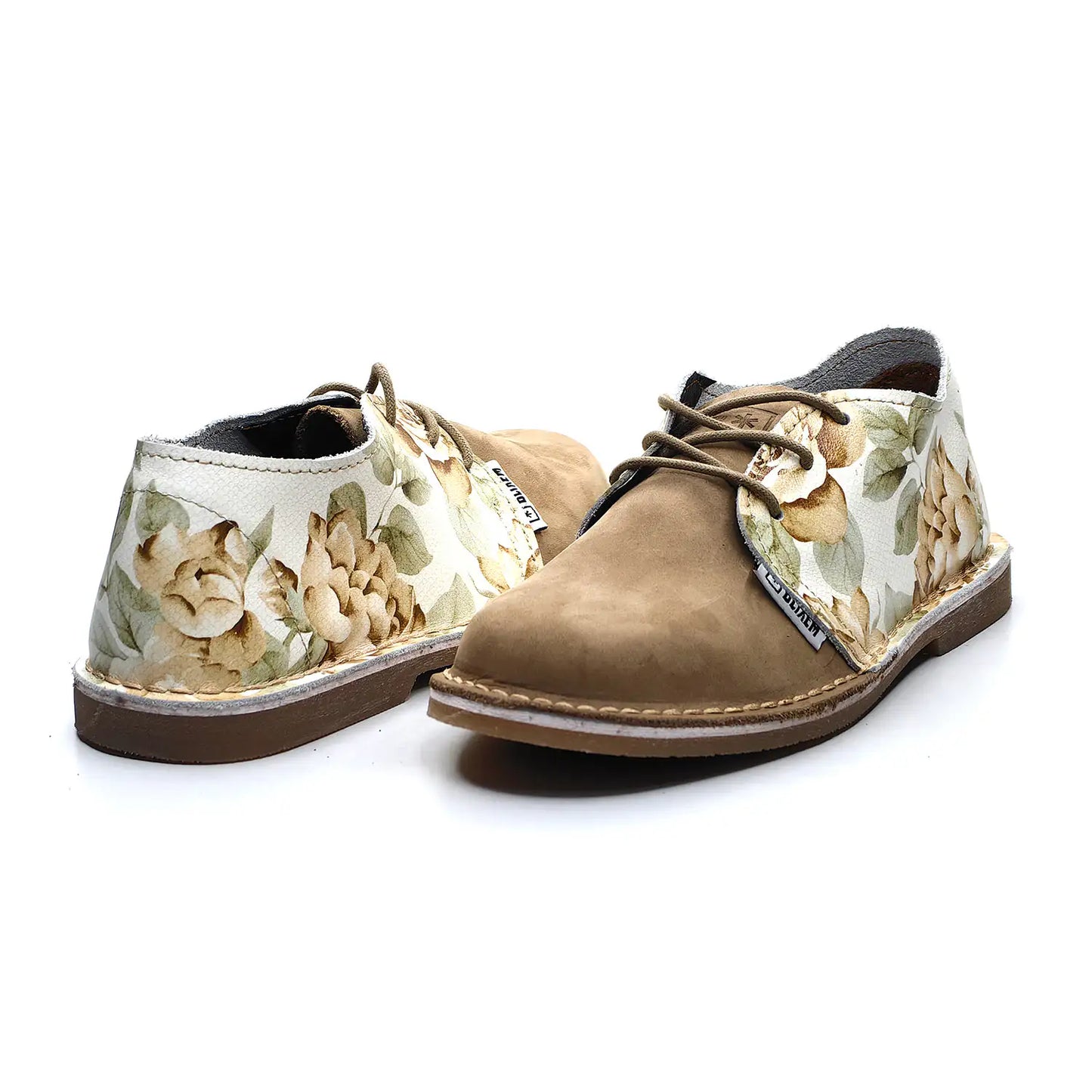 Pair of brown nubuck shoes with floral patterned soles on a white background