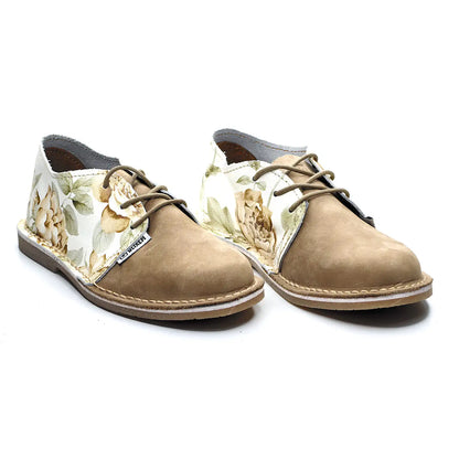 Pair of tan shoes with floral pattern on a white background