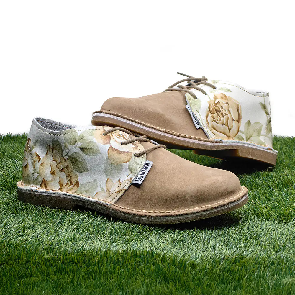 Pair of brown shoes with floral patterns on grass