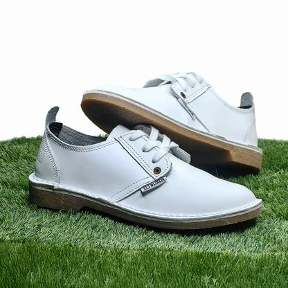 White shoes with brown soles on a grassy surface